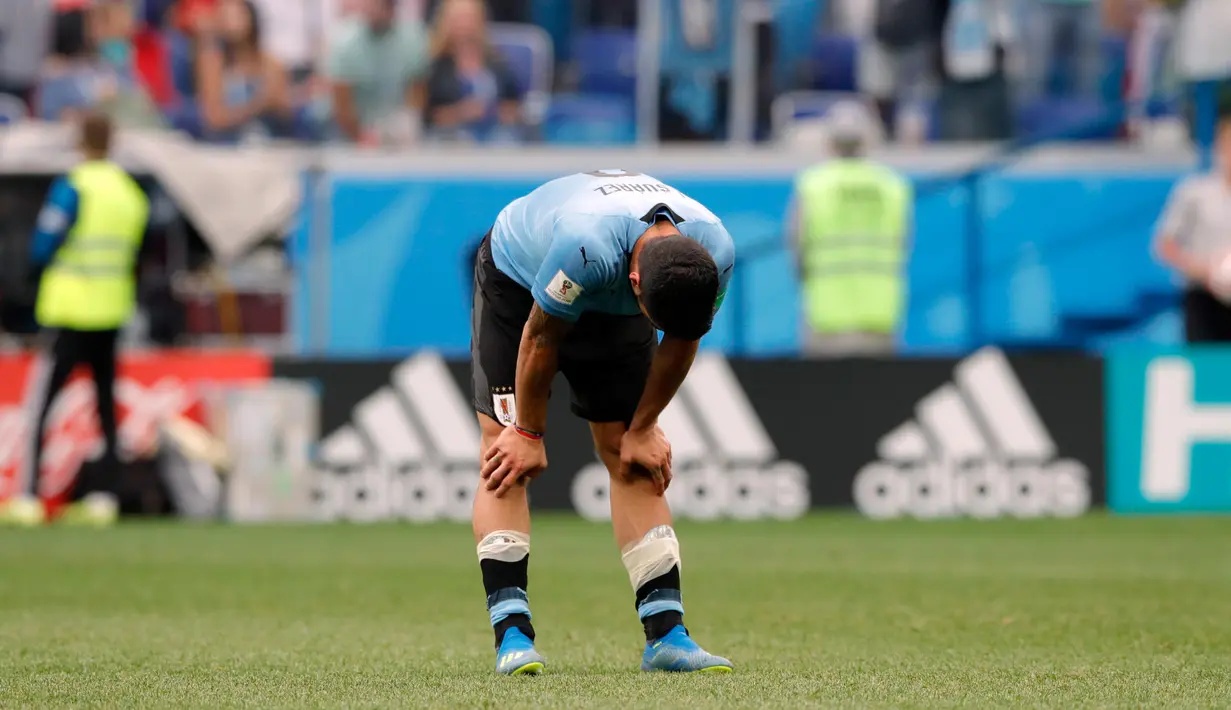 Striker Uruguay, Luis Suarez menunduk bersedih setelah kalah atas Prancis pada perempat final Piala Dunia 2018 di Nizhny Novgorod Stadium, Jumat (6/7). Timnas Uruguay tersingkir usai ditumbangkan Prancis dua gol tanpa balas. (AP/Ricardo Mazalan)