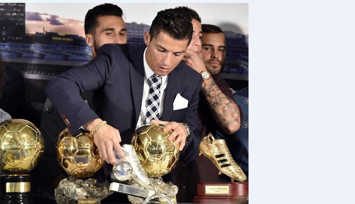Bintang Real Madrid Cristiano Ronaldo membetulkan posisi sepatu emasnya saat acara seremoni penghaargaan atas pencapain sebagai Top Skor sepanjang masa El Real di Stdion Santiago Bernabeu, Madrid, Jumat (2/10/2015).  AFP Photo / Gerard Julien