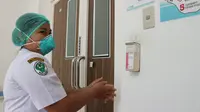 Seorang tenaga kesehatan RSUD Undata membersihkan tangan usai membersihkan ruangan pasien. (Foto: LIputan6.com/Heri Susanto)