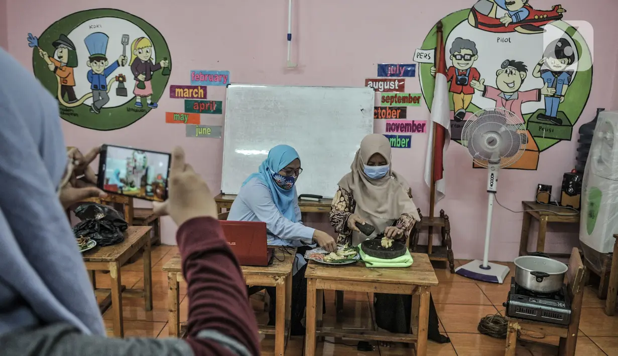 Pendidik mempraktikan pembuatan bir pletok saat kelas sentra memasak via virtual di Pendidikan Anak Usia Dini (PAUD) Cempaka, Tebet Barat, Jakarta, Senin (23/11/2020). Selama pandemi Covid-19, pendidik di PAUD Cempaka rutin menggelar kegiatan belajar secara virtual. (merdeka.com/Iqbal S Nugroho)