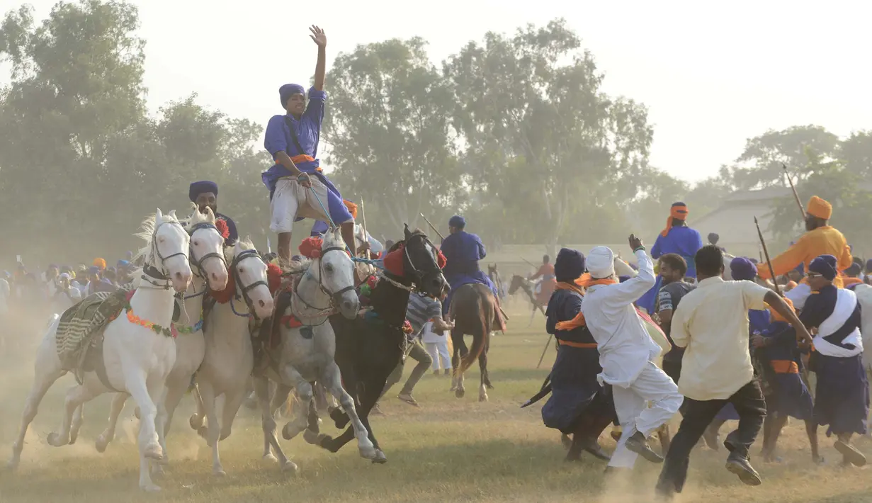 Atraksi berkuda dari anggota militer tradisional Sikh saat perayaan Fateh Divas di Amritsar (20/10). Perayaan Fateh Divas ini digelar sehari setelah festival Diwali. (AFP/Narinder Nanu)