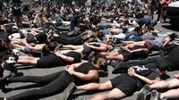 Anggota komunitas LGBTQ bersama pengunjuk rasa Black Lives Matter melakukan aksi tiarap di jalan dengan tangan seolah terikat di West Hollywood, California, Rabu (3/6/2020). Aksi menyimbolkan momen terakhir George Floyd saat lehernya ditindih lutut polisi Minneapolis pada 25 Mei. (AP/Richard Vogel)