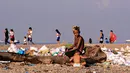 Anak-anak menyortir sampah di permukiman kumuh di sepanjang garis Pantai Baseco di Manila, Filipina (28/9/2019). Daerah memiliki pantai yang sering dikunjungi beberapa warga Manila meskipun tingkat coliform berbahaya di perairan yang berdekatan. (AFP Photo/Maria Tan)