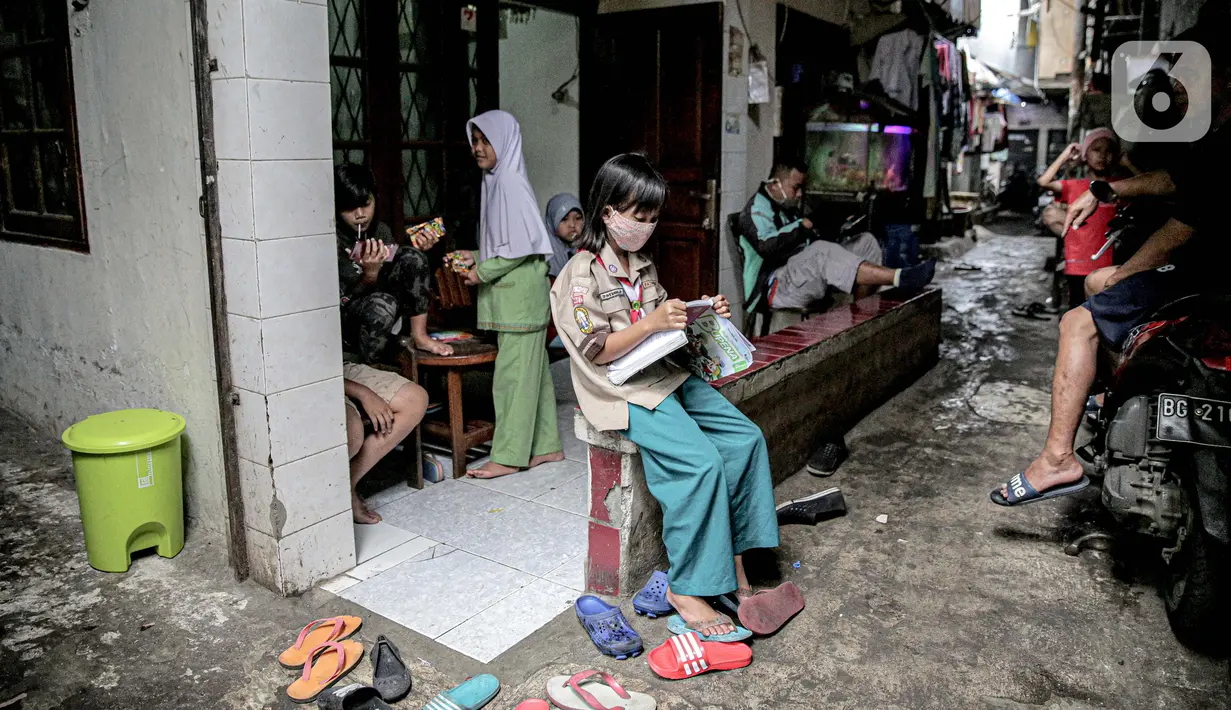 Seorang murid SD mengikuti kegiatan pembelajaran jarak jauh di depan rumahnya di RT 003 RW 006 Bendungan Hilir, Tanah Abang, Jakarta, Jumat (14/8/2020). Selama Covid-19, anak-anak memanfaatkan televisi yang ada untuk mengikuti pelajaran sekolah yang disiarkan TVRI. (Liputan6.com/Faizal Fanani)
