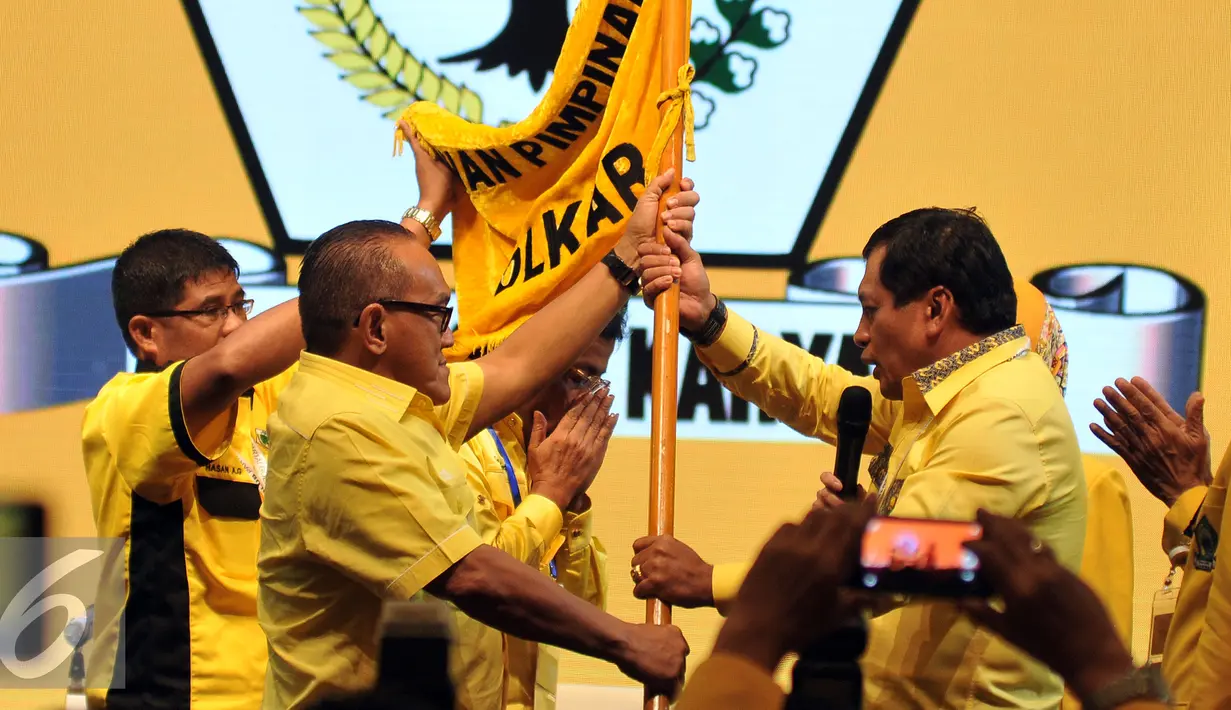 Ketua Umum Partai Golkar Aburizal Bakrie (kiri), memberikan Panji Partai Golkar kepada Pimpinan Rapat Nurdin Halid seusai memberikan Pidato terakhirnya di  Musyawarah Nasional Luar Biasa (Munaslub) di Nusa Dua, Bali (16/5). (Liputan6.com/Johan Tallo)