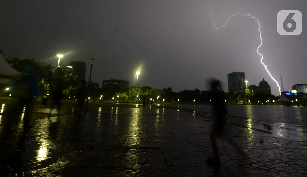Kilatan petir menyambar di kawasan Monas, saat hujan yang disertai angin mengguyur Jakarta, Sabtu (21/12/2019),Malam. BMKG mengingatkan agar waspada terhadap potensi hujan deras yang disertai petir diprediksi akan terjadi dalam beberapa hari kedepan. (merdeka.com/Imam Buhori)
