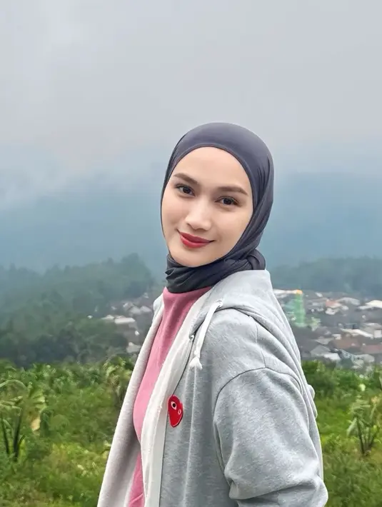 Berkunjung ke Telomoyo, Melody Laksani mengenakan inner t shirt warna pink dipadukan jaket hoodie abu-abu. [@melodylaksani92]
