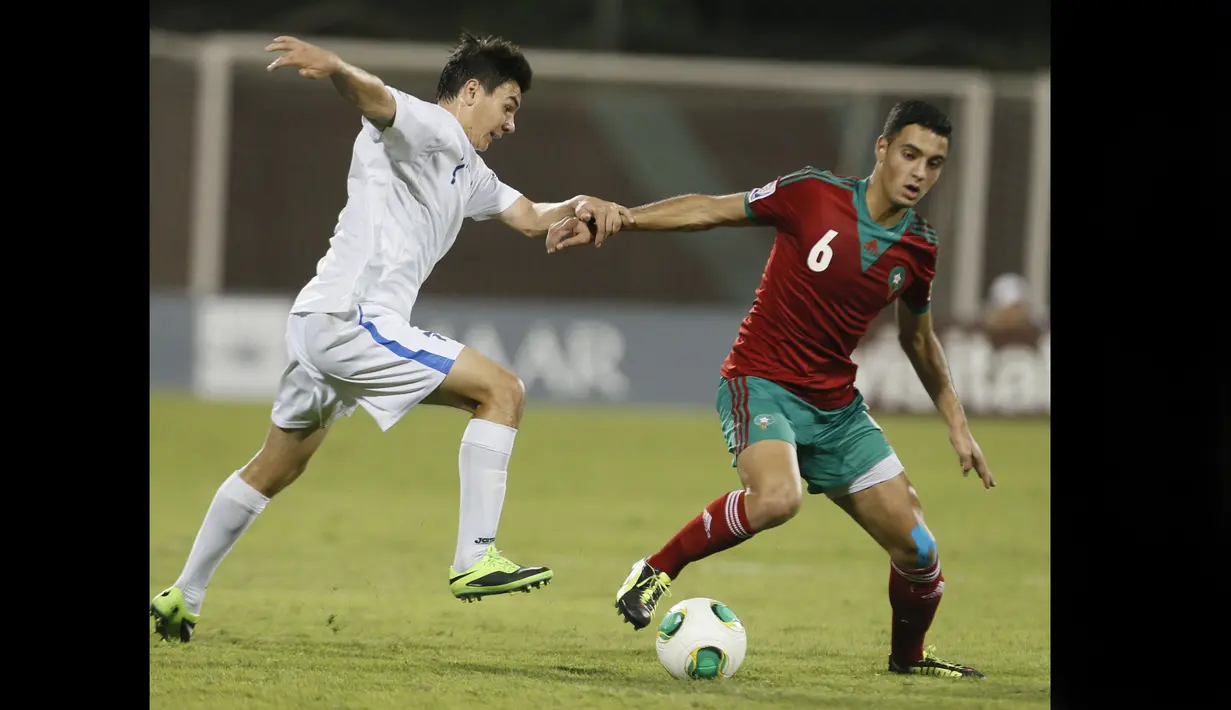 Pemain Timnas Maroko U-17, Sofyan Amrabat (kanan), mengontrol bola dibayangi pemain Uzbekistan U-17, amshid Boltaboev, dalam pertandingan Piala Dunia U-17 2013 yang berlangsung di Uni Emirat Arab, Senin (21/10/2013). Sofyan Amrabat diberikan kesempatan bermain tiga kali bersama Timnas Maroko U-17 di Piala Dunia U-17 2013. (AFP/Karim Sahib)