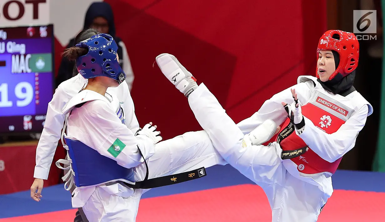Atlet taekwondo putri Indonesia, Fitriyana Yusuf berhadapan dengan Liu Qing dari Makau pada babak 16 besar di Jakarta Convention Center (JCC), Senin (20/8). Fitriyana kalah tipis 21 - 25 pada kelas Wanita 67 kg. (Liputan6.com/Fery Pradolo)
