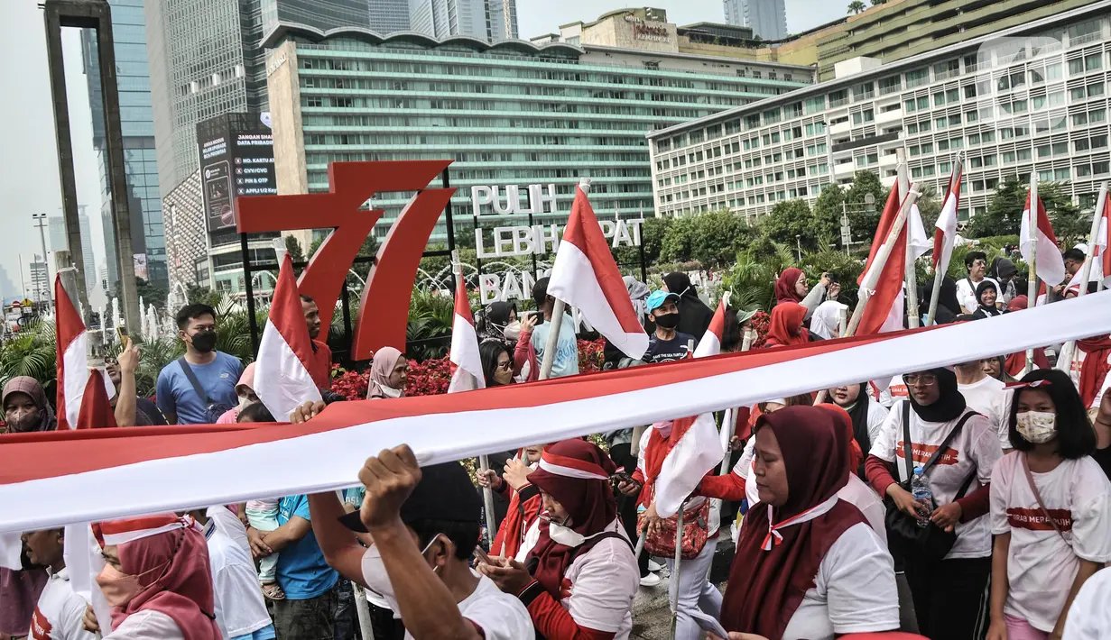 Peserta membentangkan bendera Merah Putih raksasa di kawasan Bundaran HI, Jakarta Pusat, Minggu (28/8/2022). Sebanyak 50.000 orang membentangkan bendera merah putih sepanjang 1.700 meter dari kawasan Monas hingga Bundaran HI yang merupakan rangkaian dalam memperingati Hari Kemerdekaan Indonesia dengan tema 'Pulih Lebih Cepat, Bangkit Lebih Kuat. (merdeka.com/Iqbal S Nugroho)