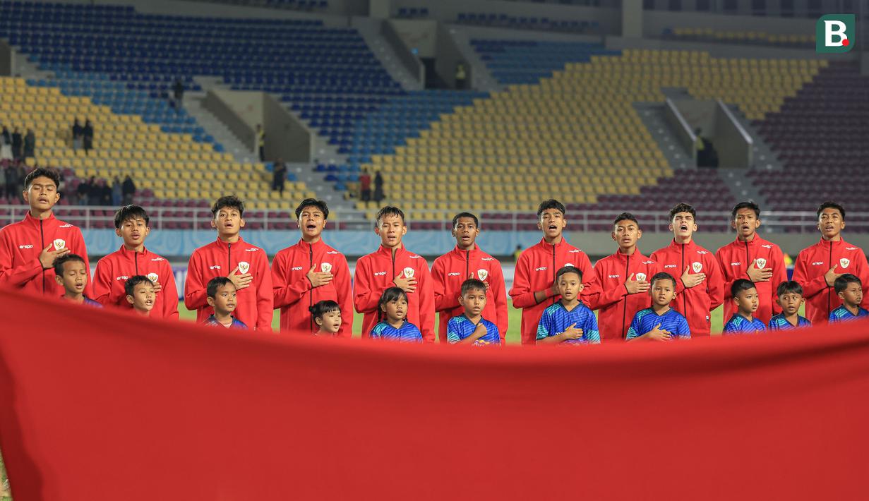 <p>Para pemain starting XI Timnas Indonesia U-16 berbaris sambil menyanyikan lagu kebangsaan Indonesia Raya jelang dimulainya laga matchday pertama Grup A Piala AFF U-16 2024 menghadapi Timnas Singapura U-16 di Stadion Manahan, Solo, Jumat (21/6/2024). (Bola.com/Radifa Arsa)</p>