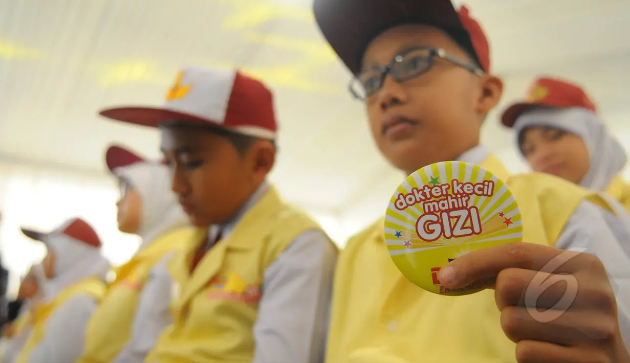 Seorang siswa menunjukkan pin Dokter Kecil-Mahir Gizi, Jakarta, Jumat (20/3/2015). (Liputan6.com/Herman Zakharia)
