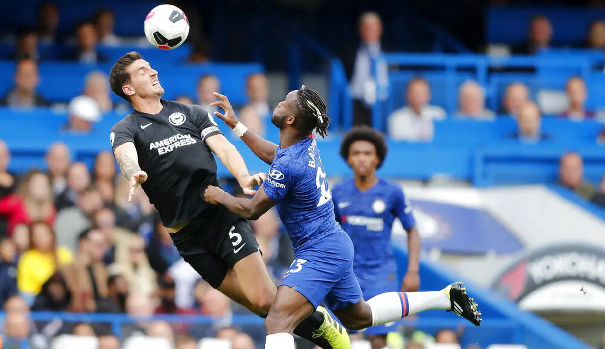 Penyerang Chelsea, Michy Batshuayi, duel udara dengan pemain Brighton & Hove Albion, Lewis Dunk, pada laga Premier League di Stadion Stamford Bridge, Sabtu (28/9). Chelsea menang 2-0. (AP/Frank Augstein)