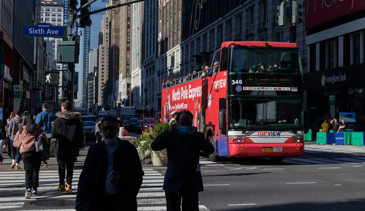 Wisatawan yang bepergian berkendara melalui Herald Square di New York pada 9 November 2021. Turis asing yang mendatangi Amerika Serikat disambut kembali ke New York City untuk pertama kalinya dalam 20 bulan setelah pembatasan perjalanan pandemi Covid-19 dicabut. (ANGELA WEISS / AFP)