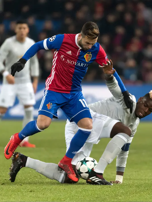 Pemain FC Basel, Renato Steffen berebut bola dengan pemain Manchester United, Paul Pogba pada matchday kelima Grup A Liga Champions di Stadion St Jakob Park, Rabu (22/11). Manchester United takluk 0-1 di markas Basel. (Georgios Kefalas/Keystone via AP)