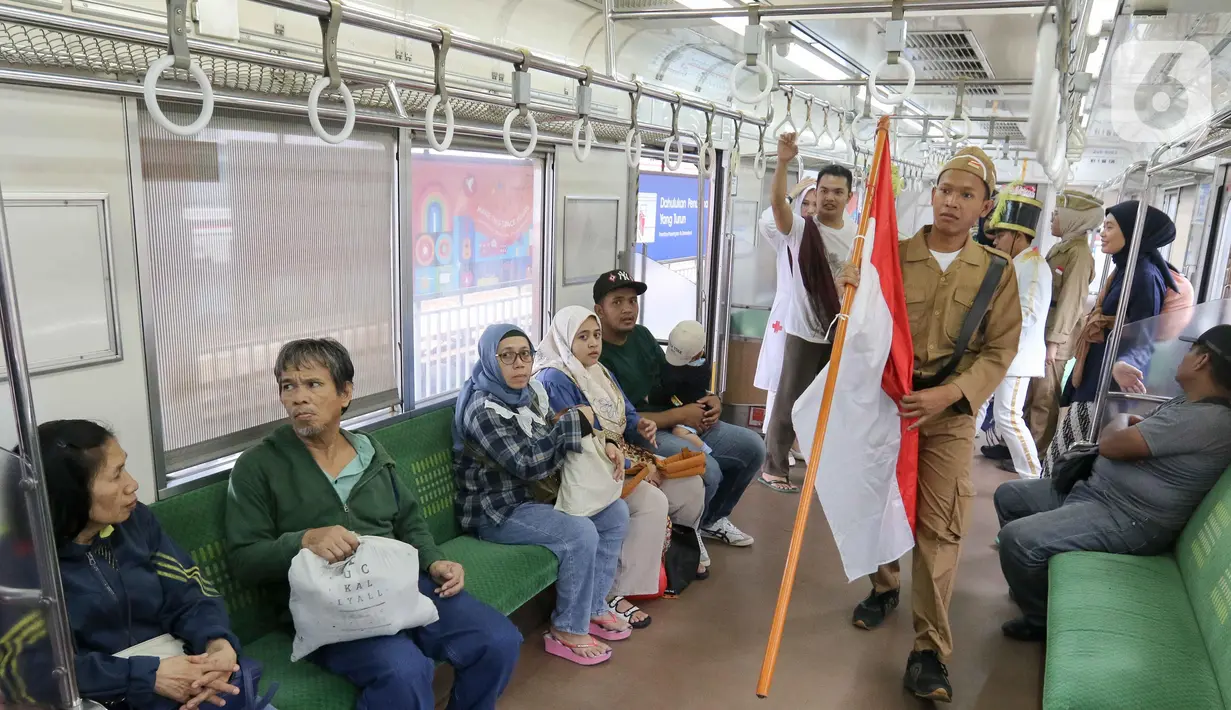 Petugas KAI Commuter menampilkan aksi teatrikal Pertempuran 10 November 1945 di Stasiun Jakarta Kota, Jakarta, Senin (11/11/2024). (Liputan6.com/Herman Zakharia)