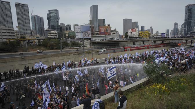 Para pengunjuk rasa memblokir jalan raya utama di tepi laut Tel Aviv dan polisi menggunakan meriam air untuk membubarkan para demonstran di kota itu dan Haifa di utara. (AP Photo/Oded Balilty)