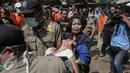 Seorang warga terlihat pingsan usai menyaksikan petugas merobohkan bangunan tempat tinggalnya saat penggusuran terjadi di Rawasari Selatan, Jakarta, Kamis (23/7/2015). Tampak upaya petugas mengevakuasi warga yang pingsan. (Liputan6.com/Faizal Fanani)
