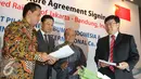 Presiden Direktur PT PSBI Dwi Windarto (kiri) memberikan dokumen kepada Yang Zhong Min (kanan) usai penandatanganan perjanjian pendirian perusahaan patungan di Jakarta, Jumat (16/10/2015). (Liputan6.com/Angga Yuniar)