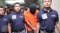 Tersangka pembunuhan bocah yang ditemukan tewas didalam kardus di Kalideres, Agus alias A, dibawa petugas untuk dihadirkan di hadapan media dalam jumpa pers di Polda Metro Jaya, Jakarta, Sabtu (10/10/2015). (Liputan6.com/Angga Yuniar)