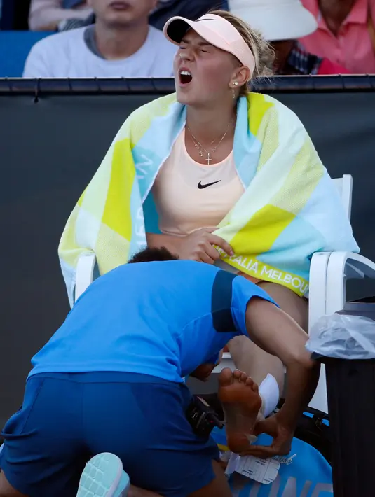 Petenis Ukraina Marta Kostyuk menerima perawatan saat pertandingan melawan Peng Shuai di Australia Terbuka di Melbourne, (15/1). Marta Kostyuk menang 6-2, 6-2 atas Peng Shuai dari China. (AP Photo/Ng Han Guan)