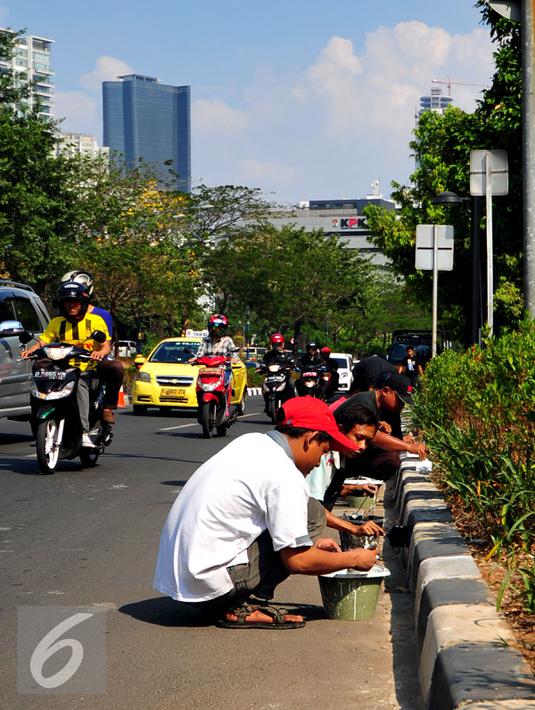 Sejumlah pekerja saat mengecat separator jalan di kawasan HR Rasuna Said, Jakarta, Kamis (30/7/2015). Menyambut Hari Kemerdekaan, Pemprov DKI Jakarta akan mempercantik wajah Ibukota. (Liputan6.com/Yoppy Renato)