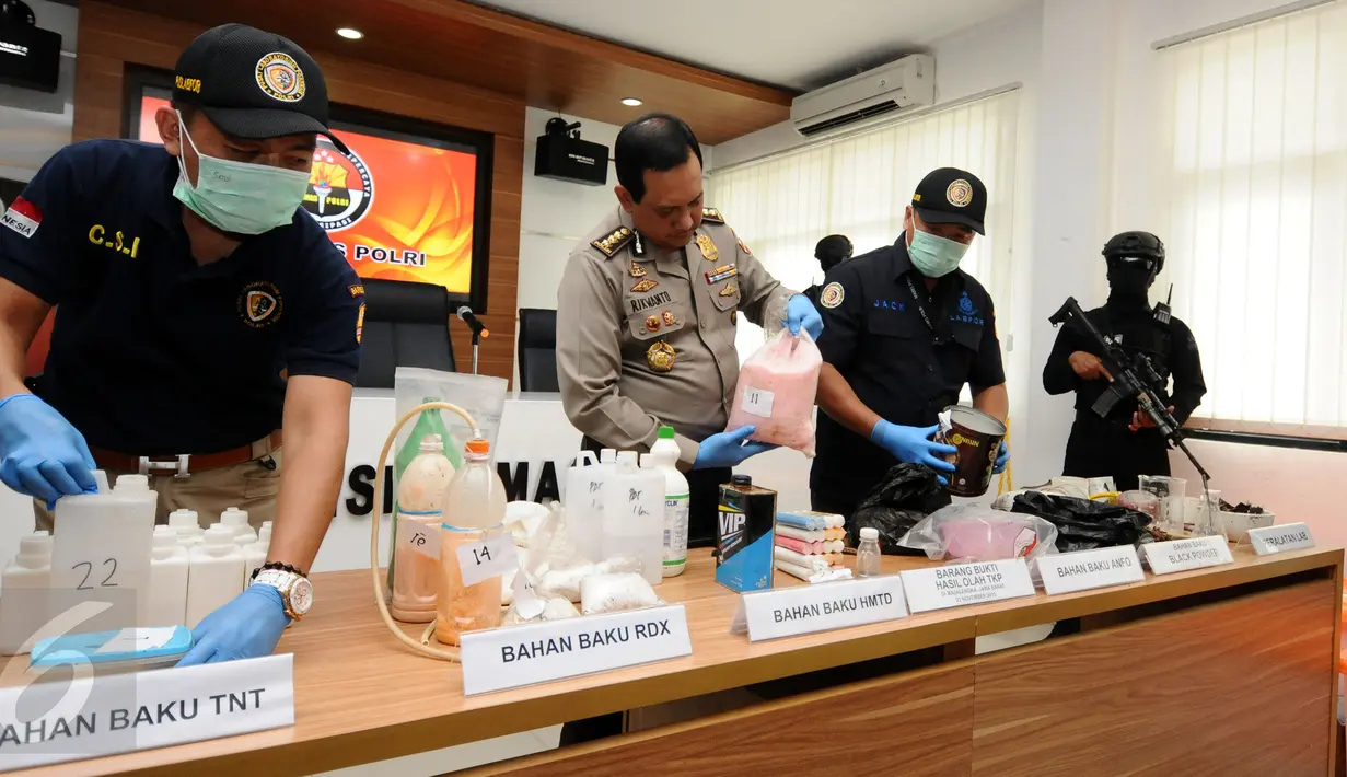 Kepala Biro Penmas Mabes Polri Kombes Pol Rikwanto (tengah) melihat barang bukti bahan racikan bom di Jakarta, Jumat (25/11). Tim Densus 88 Mabes Polri menahan satu orang terduga teroris berikut bahan racikan bom. (Liputan6.com/Helmi Fithriansyah)