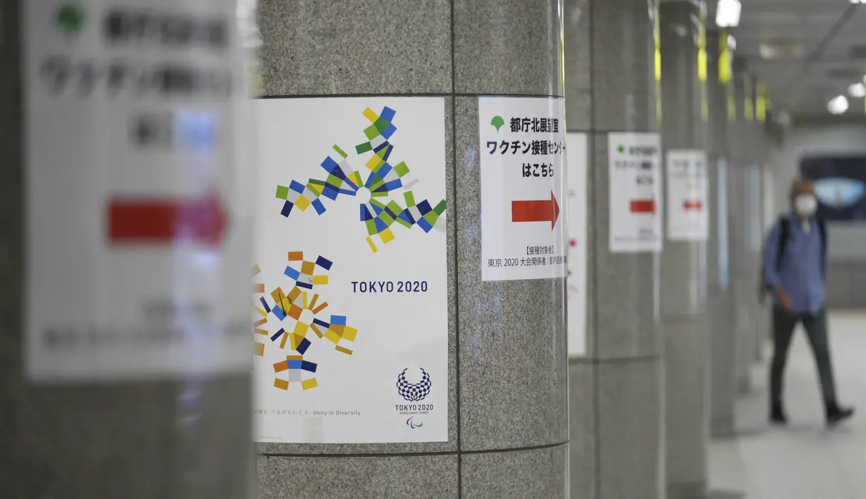 Tanda-tanda menuju tempat vaksin ditempatkan di kolom stasiun kereta bawah tanah di Tokyo, Selasa (22/6/2021). Ibu kota Jepang mengkonfirmasi lebih dari 430 kasus virus corona baru pada hari Selasa. (AP Photo/Eugene Hoshiko)
