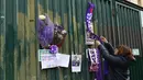 Penggemar menggantung syal ungu Fiorentina di pagar luar Stadion Artemio Franchi di Florence, Minggu (4/3). Fans melakukan aksi belasungkawa untuk mengenang sosok kapten Fiorentina Davide Astori yang meninggal dalam tidurnya. (Claudio GIOVANNINI/AFP)