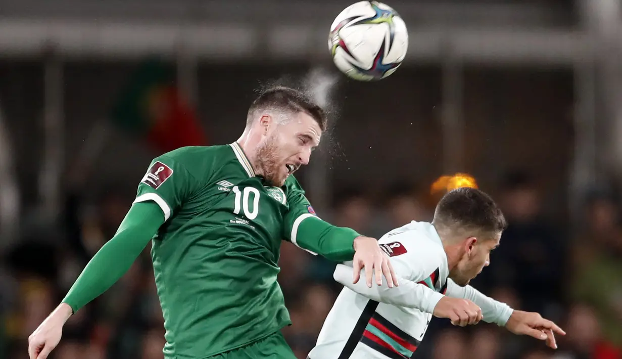 Bek timnas Irlandia, Matt Doherty menyundul bola di atas penyerang Portugal Andre Silva pada laga Grup A Kualifikasi Piala Dunia 2022 Zona Eropa di Stadion Aviva, Jumat (12/11/2021) dinihari WIB. Diwarnai kartu merah Pepe, Portugal ditahan imbang 0-0 oleh Irlandia. (AP Photo/Peter Morrison)