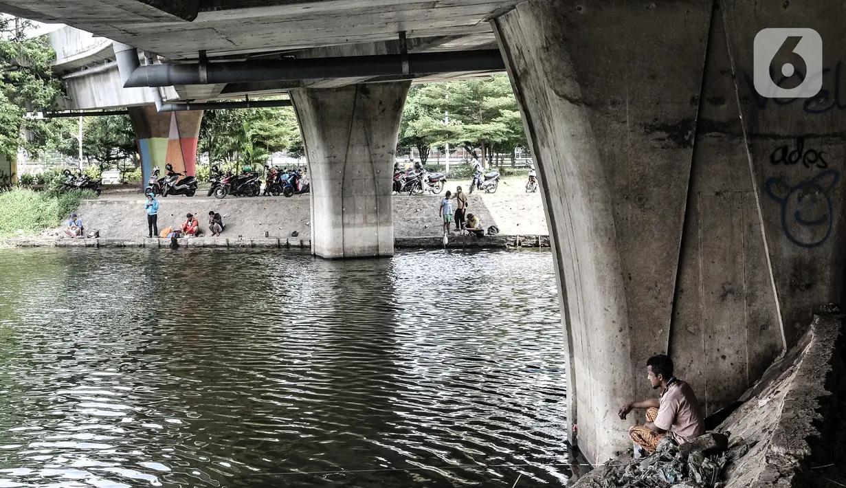 Aktivitas warga saat memancing di waduk kawasan Sungai Bambu, Tanjung Priok, Jakarta, Minggu (17/1/2021). Waduk buatan yang tepat berada di bawah Jalan Tol Pelabuhan tersebut menjadi wisata alternatif menghabiskan akhir pekan tanpa mengeluarkan biaya atau gratis. (merdeka.com/Iqbal S. Nugroho)