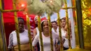 Narapidana wanita tersenyum dari balik sel di Penjara Nelson Hungria, Rio de Janeiro, Brasil, Kamis (13/12). Para narapidana mendekorasi ruangan mereka dengan hiasan untuk menyambut Natal. (AP Photo/Silvia Izquierdo)