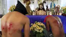 Pria berdoa dengan memakai topeng pada acara kamis putih di kota Mandaluyong, Manila, Filipina, (24/3). Tradisi cambuk merupakan tradisi yang dilakukan oleh beberapa umat Katolik Filipina untuk menyambut hari Paskah. (REUTERS / Romeo Ranoco)