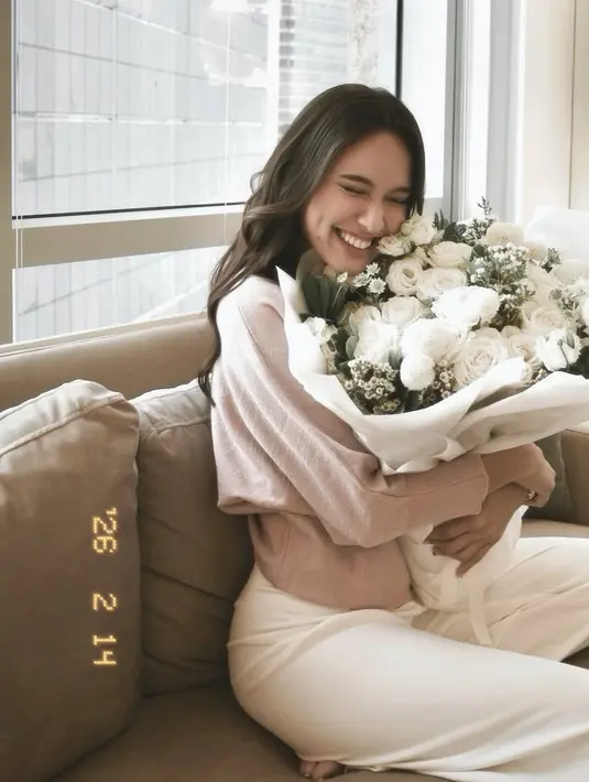 Mengenakan atasan lengan panjang dipadukan celana panjang putih, Yasmin Napper pun menerima buket bunga mawar putih. [@yasminnapper]