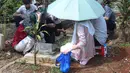 Suasana haru dan penuh khidmat terasa saat warga membersihkan makam, menaburkan bunga, serta memanjatkan doa. Tampak dalam foto, warga saat melakukan ziarah kubur usai melaksanakan salat Idulfitri 1447 Hijriah di salah satu Tempat Pemakaman Umum (TPU), Cibinong, Kabupaten Bogor, Jawa Barat, Sabtu (21/3/2026). (Kapanlagi.com/Budy Santoso)