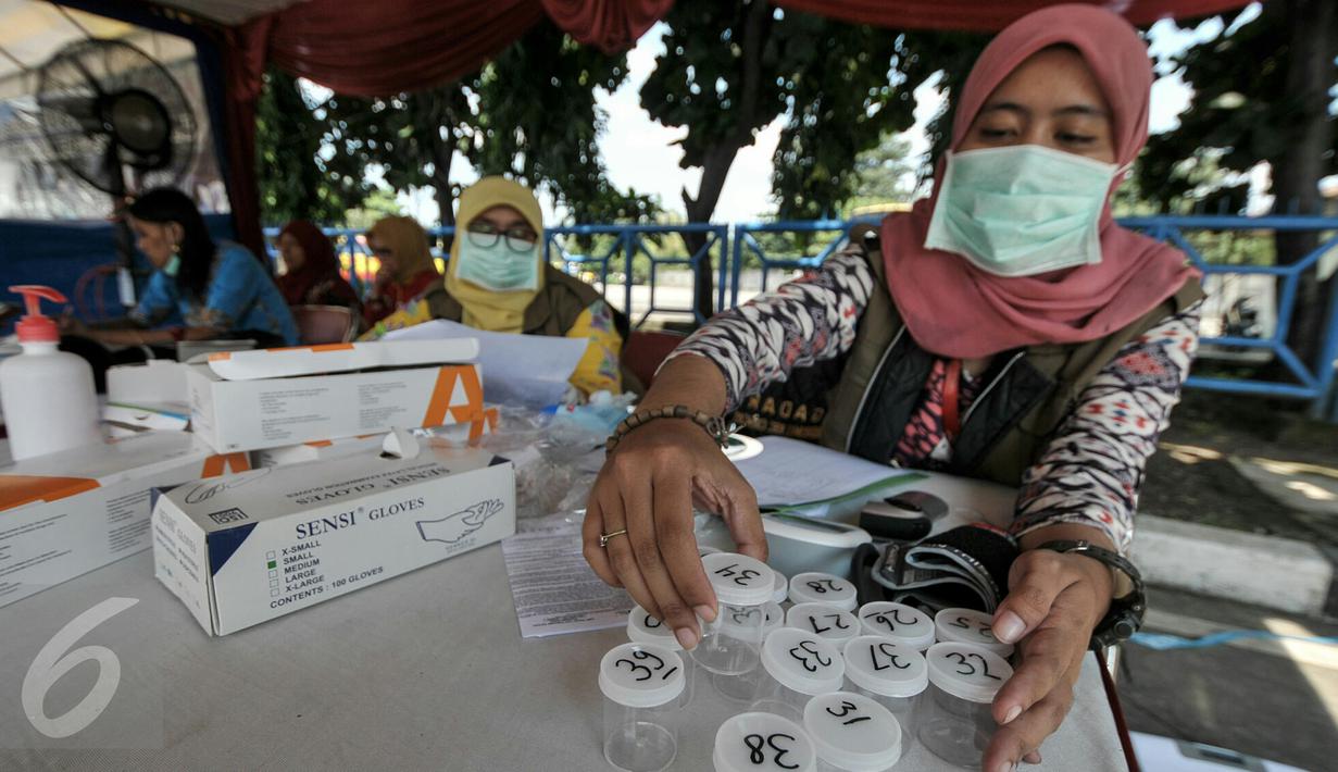 Petugas melakukan tes urine pengemudi bus di pos kesehatan Terminal Kampung Rambutan, Jakarta, Jumat (24/6). Dishub DKI Jakarta melakukan cek kesehatan pengemudi dan kelayakan armada bus jelang arus mudik Lebaran 2016. (Liputan6.com/Yoppy Renato)