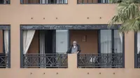 Seorang pria berdiri di balkon hotel H10 Costa Adeje Palace di La Caleta, di Pulau Canary Tenerife, Spanyol, Kamis  (27/2/2020). Pemerintah Spanyol mengatakan sekitar 1.000 orang di Hotel H10 tersebut diisolasi usai adanya temuan positif virus corona COVID-19. (AP Photo/Joan Mateu)