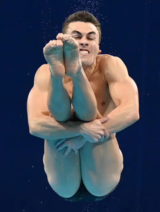 Anton Down-Jenkins, pelompat indah Selandia Baru, bertanding dalam babak semifinal Loncat indah putra 3 meter Springboard Olimpiade Tokyo 2020 di Tokyo Aquatics Center, Selasa (3/8/2021). (Attila KISBENEDEK / AFP)
