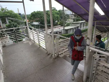 Warga melintasi Jembatan Penyeberangan Orang di kawasan Tanjung Barat, Jakarta, Jumat (11/11).Buruknya desain menyebabkan JPO tersebut tidak tersambung, sehingga warga harus membeli tiket kereta jika ingin menyeberang. (Liputan6.com/Immanuel Antonius)