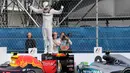 Lewis Hamilton merayakan kemenangannya diatas mobil seusai balapan F1 Grand Prix Meksiko, Meksiko (30/10). Kemenangan ini jadi yang kedua beruntun didapat Hamilton setelah Grand Prix Amerika Serikat pekan lalu. (Reuters/Henry Romero)