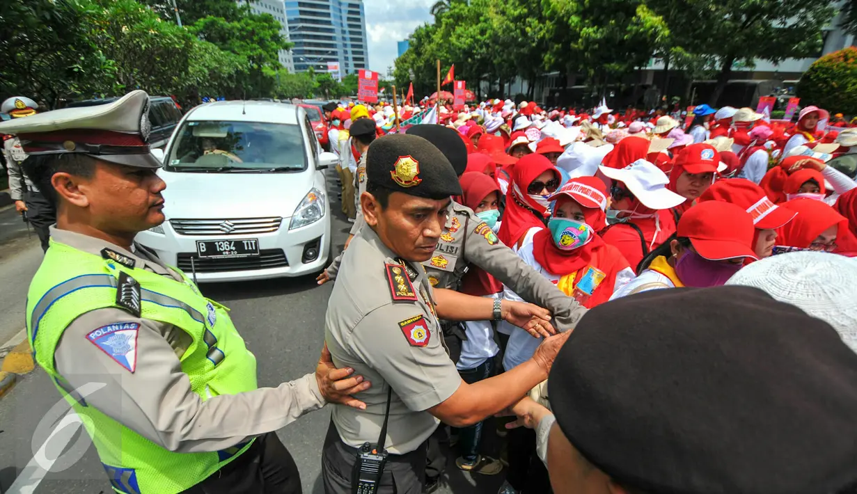 Petugas kepolisian membantu rekannya menertibkan demonstrasi ratusan bidan desa yang menutup akses jalan di depan gedung Kemenkes, Jakarta, Rabu (4/5). Para bidan tersebut menuntut diangkat menjadi pegawai tetap tanpa syarat.  (Liputan6.com/Yoppy Renato)