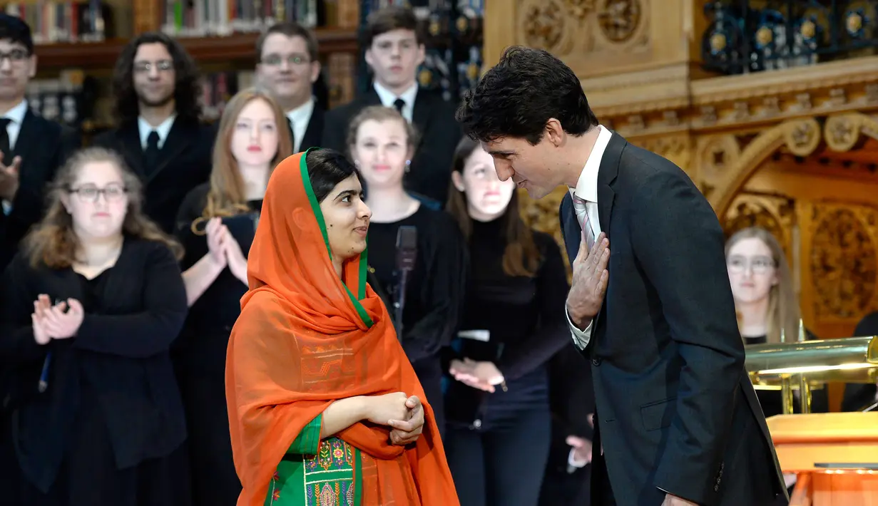 PM Kanada Justin Trudeau memberikan salam kepada aktivis muda pemenang Penghargaan Nobel Perdamaian, Malala Yousafzai pada upacara pemberian hadiah kewarganegaraan di Gedung Parlemen Kanada di Ottawa, Rabu (12/4). (Justin Tang/The Canadian Press via AP)
