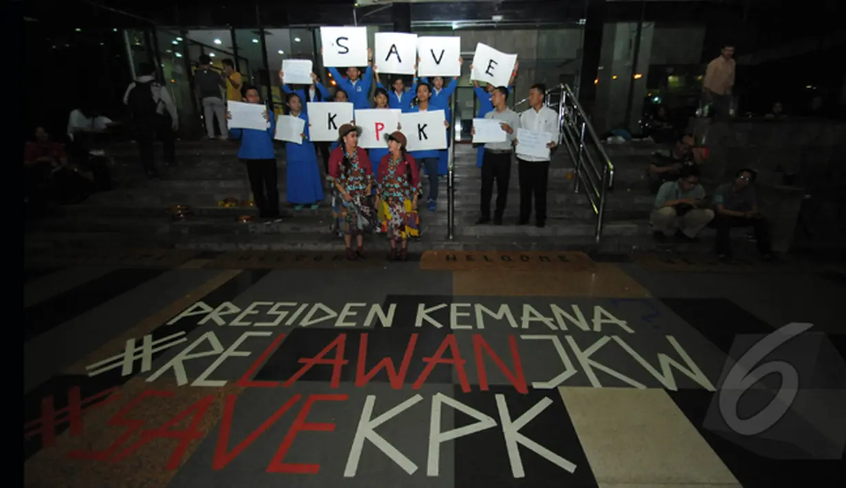 Guru kembar dan para siswanya saat menunjukkan aksi dukungan kepada KPK. Tampak sebuah tulisan #save KPK di depan jalan gedung KPK, Jakarta, Senin (26/1/2015). (Liputan6.com/Herman Zakharia)