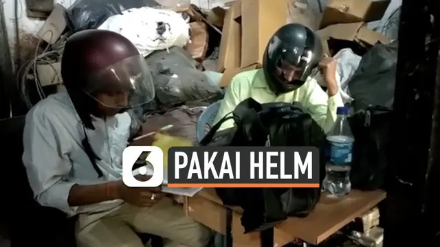 Pegawai kantor pemerintahan India menggunakan helm motor saat bekerja. Ini dilakukan agar kepala mereka tetap aman saat bekerja karena gedung kantor yang rusak.