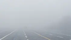 Orang-orang berjalan di Lapangan Merah tanpa terlihat Menara Spasskaya dan Katedral St. Basil tertutup kabut di Moskow, Rusia, Selasa (2/11/2021).  Kabut tebal menyelimuti ibu kota Rusia pada Selasa, menyebabkan banyak penundaan penerbangan di bandara Moskow. (AP Photo/Pavel Golovkin)