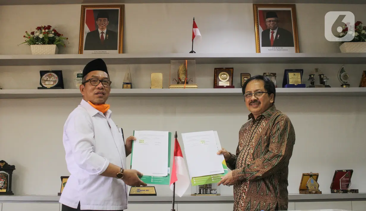 Direktur KSKK Madrasah Ditjen Pendis Kemenag Dr. A. Umar, M.A (kiri) dan Presdir Smartfren Merza Fachys (kanan) usai menandatangani nota kerjasama pemberian kartu perdana Smartfren gratis untuk Madrasah se-Indonesia untuk mendukung program PJJ, di Jakarta, Senin (21/9/2020). (Liputan6.com/HO/Agus)