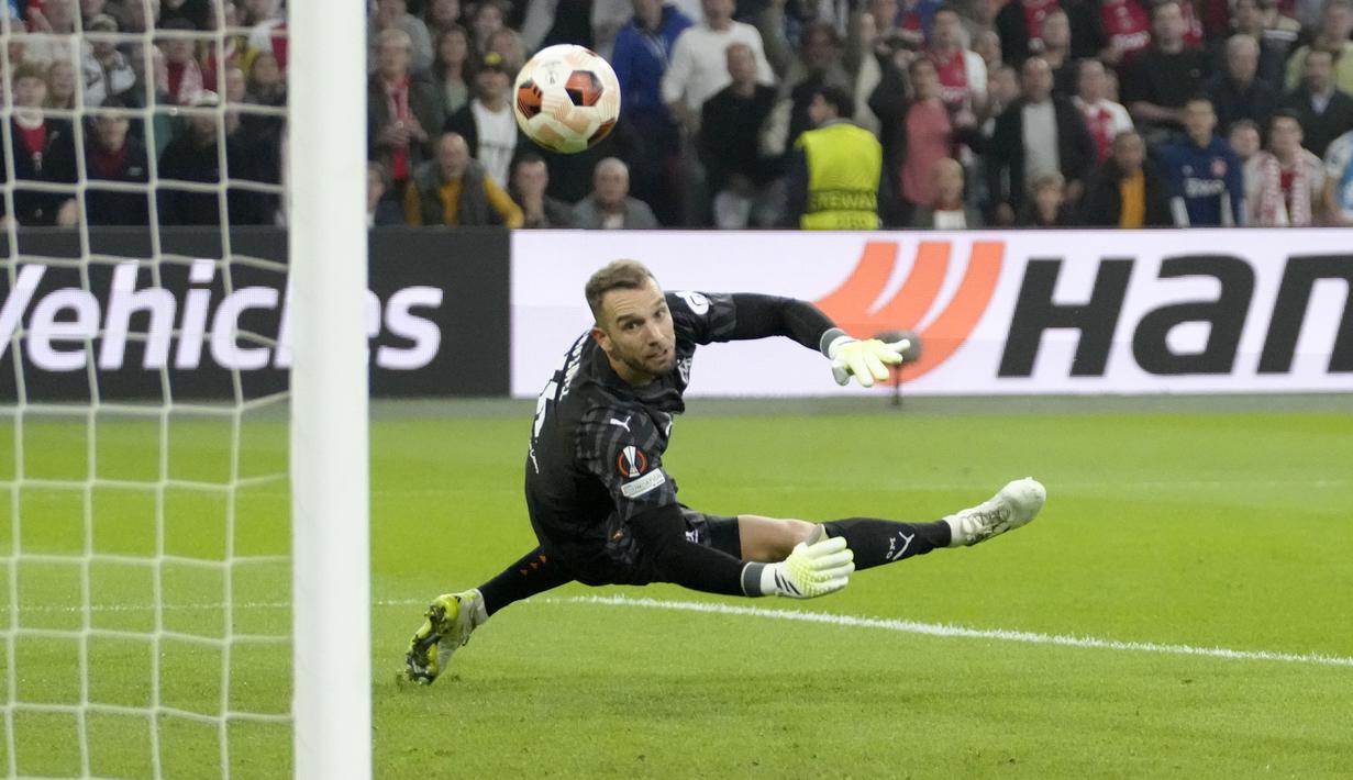 Kiper Marseille, Pau Lopez berusaha menghalau tendangan pemain Ajax Amsterdam, Kenneth Taylor pada laga matchday pertama Grup B Liga Europa 2023/2024 di Johan Cruijff ArenA, Amsterdam, Belanda pada Jumat (22/09/2023) dini hari WIB. Laga berakhir dengan skor 3-3. (AP Photo/Peter Dejong)
