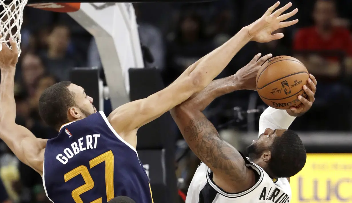 Pemain San Antonio Spurs, LaMarcus Aldridge #12 mencoba memasukan bola saat dihadang pemain Utah Jazz, Rudy Gobert #27 pada laga NBA basketball game di AT&T Center, San Antonio, (1/10/2016). Utah menang 106-91. (AP/Eric Gay)