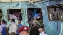 Petugas penyelamat berusaha mencari korban yang terjebak di dalam bangkai kereta usai tabrakan di Kota Alexandria, Mesir (11/8). (AFP Photo/Khaled Deouki)