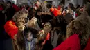 Anak-anak mengenakan kostum dari bulu beruang menari saat parade di Comanesti, utara Rumania, Jumat, 30 Desember 2022. Dentuman genderang dimulai pagi-pagi sekali menandakan kedatangan ratusan orang yang turun ke kota Comanesti yang mengenakan kostum terbuat dari bulu beruang dengan kepala yang masih menempel. . (AP Photo/Vadim Ghirda)